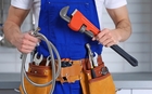 Plumber-with-plumbing-equipment-and-replacement-parts-in-kitchen