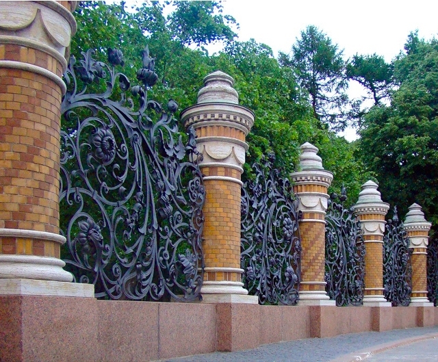 Кованый забор с кирпичными столбами